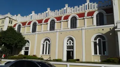 a large yellow and red building with a car parked in front at Posada Mar azul in La Viva