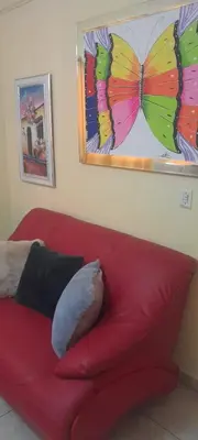 a red couch with a butterfly painting on the wall at Posada Mar azul in La Viva