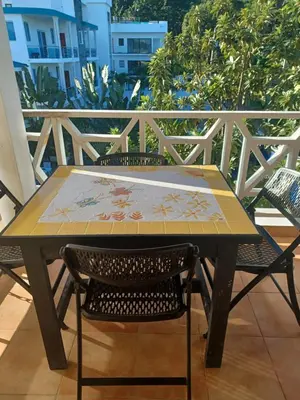 a table with a map on it on a balcony at Tropical Doña Mayra apartahotel in Las Terrenas