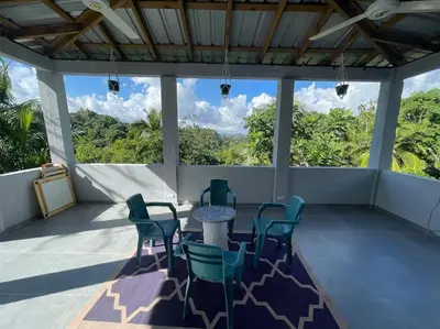 a patio with chairs and a table and a view at Country home in the hills of Samana in Santa Bárbara de Samaná