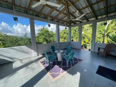 a patio with chairs and a table and some trees at Country home in the hills of Samana in Santa Bárbara de Samaná