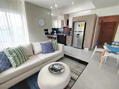 a living room with a couch and a kitchen at Refa 304 in Santo Domingo