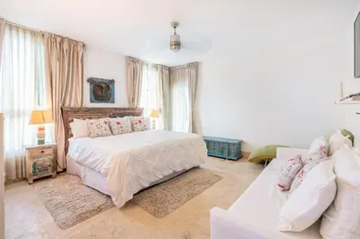 a white bedroom with a bed and a couch at 3BR apartment with beach access and ocean view in Juan Dolio