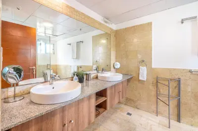 a bathroom with two sinks and a large mirror at 3BR apartment with beach access and ocean view in Juan Dolio