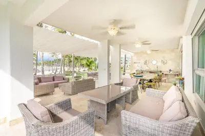 a living room with a table and chairs at 3BR apartment with beach access and ocean view in Juan Dolio