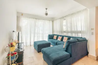 a living room with a blue couch and ottoman at 3BR apartment with beach access and ocean view in Juan Dolio