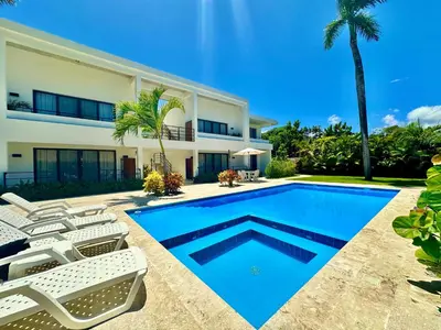 a villa with a swimming pool and a house at La Curadiña - Encuentro Surf Resort in Cabarete