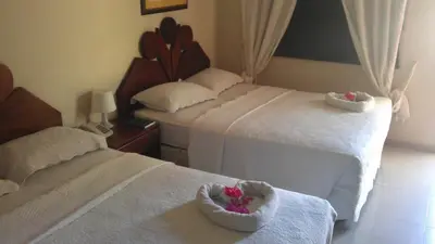 a hotel room with two beds with flowers in a basket at Hotel Tropicana Santo Domingo in La Viva