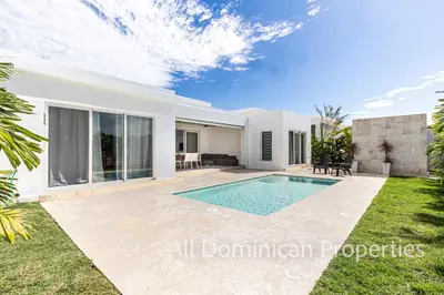 a villa with a swimming pool and a garden at Sosua Ocean Village, Villas Nuevas con piscinas privadas! in Sosúa