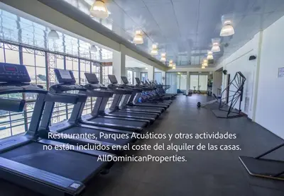 a gym with a row of treadmills and machines at Sosua Ocean Village, Villas Nuevas con piscinas privadas! in Sosúa