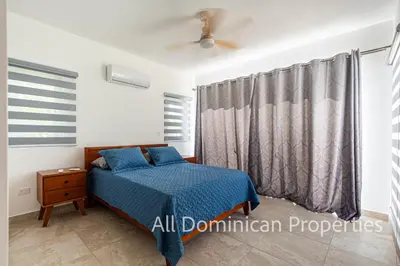 a bedroom with a bed with blue sheets and a window at Sosua Ocean Village, Villas Nuevas con piscinas privadas! in Sosúa
