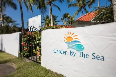 a sign for garden by the sea on a fence at Garden By The Sea in Sosúa