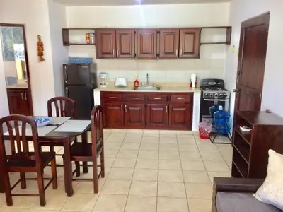 a kitchen with wooden cabinets and a table with a dining room at Cita del Sol City Apartments in Cabarete