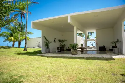 a house on the beach with palm trees at The Palm Bay Club Lodge in Nagua
