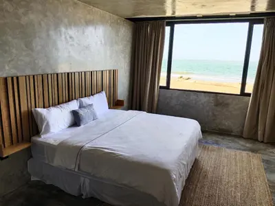a bedroom with a bed with a view of the beach at The Palm Bay Club Lodge in Nagua