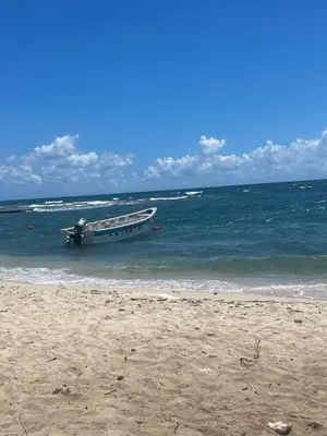 a boat sitting in the water on a beach at Cielo de cierro-Apartment with Jacuzzi, 2 minutes from the beach in La Romana