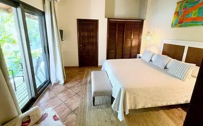 a bedroom with a bed and a large window at Villa Mariposa in Cajuiles