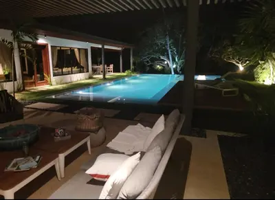 a swimming pool at night with a couch in front of it at Villa Mariposa in Cajuiles