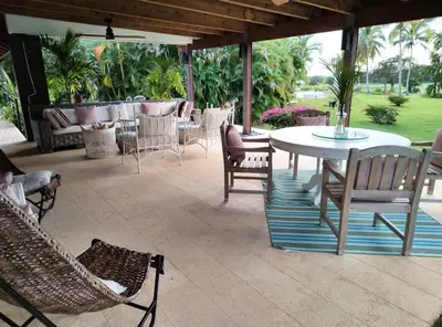 a patio with chairs and tables and a table and chairs at Villa Mariposa in Cajuiles