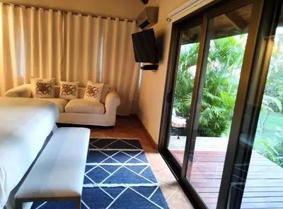 a living room with a couch and a sliding glass door at Villa Mariposa in Cajuiles