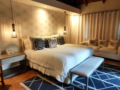a bedroom with a large bed and a couch at Villa Mariposa in Cajuiles