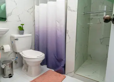 a bathroom with a toilet and a glass shower at Apartamento moderno de una habitación in San Pedro de Macorís