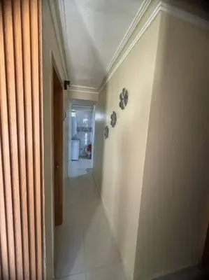 a hallway with a white wall and a room at Oasis en la Sultana del Este in San Pedro de Macorís