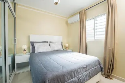 a bedroom with a bed and a large window at Oasis en la Sultana del Este in San Pedro de Macorís