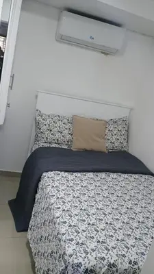 a bedroom with a bed with a white wall at Apartamento de Lujo En San Pedro in San Pedro de Macorís