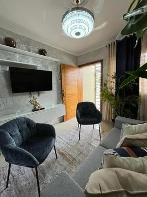 a living room with a couch and two chairs and a tv at Apartamento de Lujo En San Pedro in San Pedro de Macorís