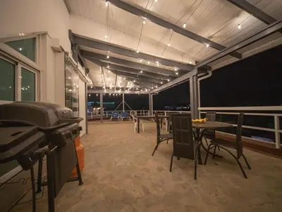 a room with tables and chairs and a grill at 3BR Luxury Penthouse, 300m From Beach in Sosúa