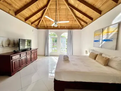 a bedroom with a large bed and a flat screen tv at Casati Pearl House, Big House With Private Pool in Bombita