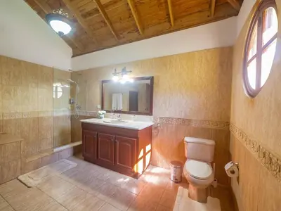 a bathroom with a sink and a toilet and a mirror at Casati Pearl House, Big House With Private Pool in Bombita