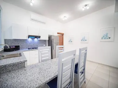 a kitchen with white cabinets and a counter top at Plaza Achim 6b, Modern Apt 250m From Sosua Beach in Sosúa