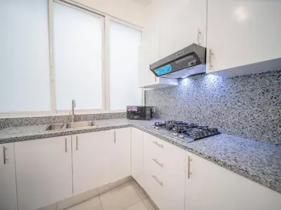 a kitchen with white cabinets and a counter top at Plaza Achim 6b, Modern Apt 250m From Sosua Beach in Sosúa