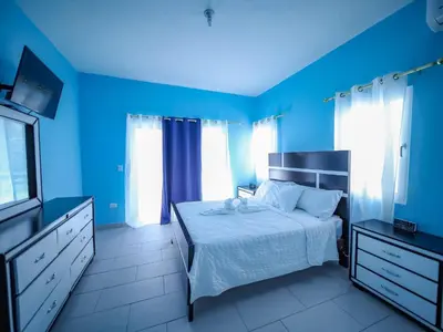 a blue bedroom with a bed and a television at 8br Private Villa In Sosa - 2 Mins From Nightlife in Sosúa