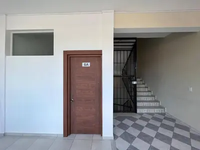 a hallway with a wooden door and stairs at Cozy 1 Bedroom Apartment in Heart of Sosa in Sosúa