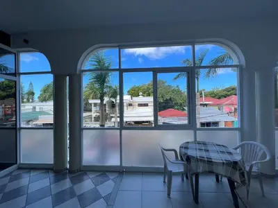 a room with a table and chairs and windows at Cozy 1 Bedroom Apartment in Heart of Sosa in Sosúa