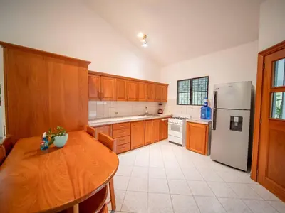 a kitchen with a wooden table and a refrigerator at Casati Family House, Great Pool Garden in Sosúa