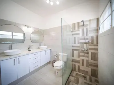 a bathroom with a toilet and a glass shower at 2BR Luxury Apartment in Heart Of Nightlife Area in Sosúa
