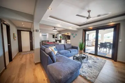 a living room with a blue couch and a table at 4br Penthouse With Rooftop Pool In Sosua Strip in Sosúa