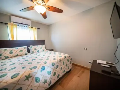 a bedroom with a bed and a ceiling fan at 4br Penthouse With Rooftop Pool In Sosua Strip in Sosúa