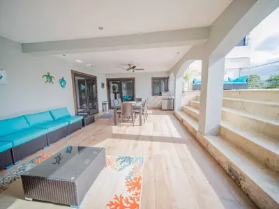 a living room with a blue couch and a table at 4br Penthouse With Rooftop Pool In Sosua Strip in Sosúa
