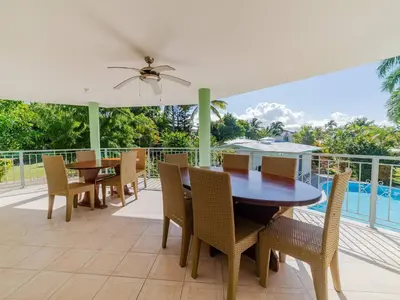 a dining room with a table and chairs on a patio at 7br Massive Villa In Sosa - 2mins From Nightlife in Sosúa