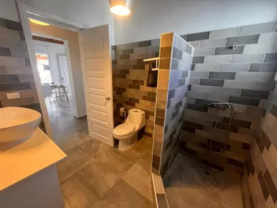 a bathroom with a toilet and a glass shower at Vittoria's House 402 in Bayahibe