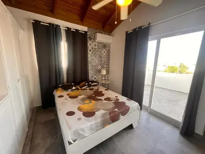 a bedroom with a bed and a large window at Vittoria's House 402 in Bayahibe