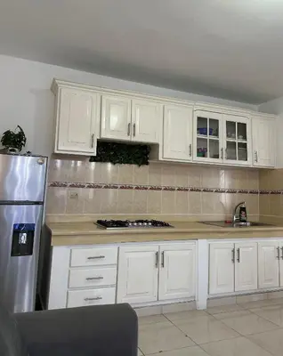 a kitchen with white cabinets and a stainless steel refrigerator at Playa Azul House in Bayahibe
