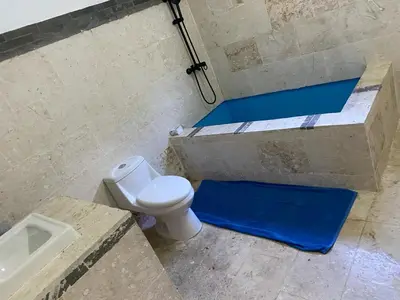 a bathroom with a toilet and a shower with blue steps at Apartamento JGB 2 in Sosúa