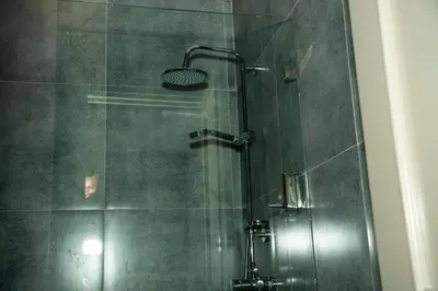 a shower with a glass door in a bathroom at Hotelito Bonito Eli & Edw in Santo Domingo