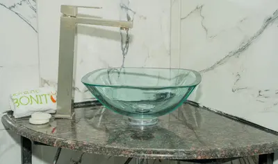 a glass bowl on a table with water pouring into it at Hotelito Bonito Eli & Edw in Santo Domingo